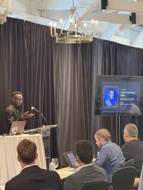 A speaker presenting beside a slide